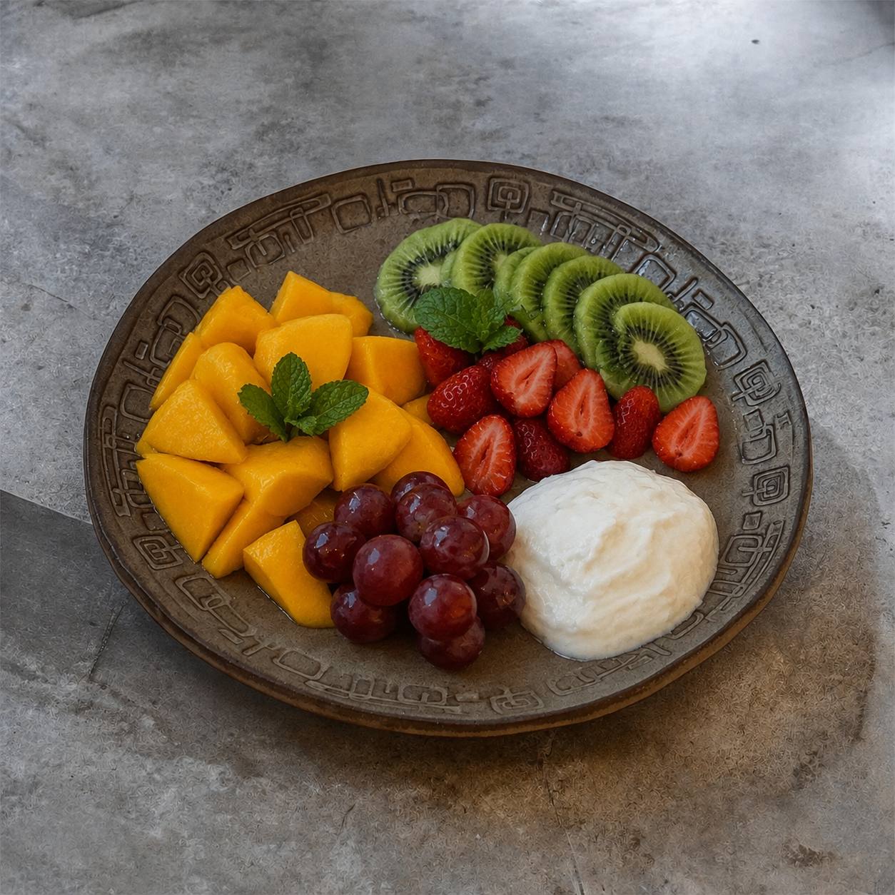 TERRA FORMAT Teller mit Mango, Kiwi, Erdbeeren und Trauben